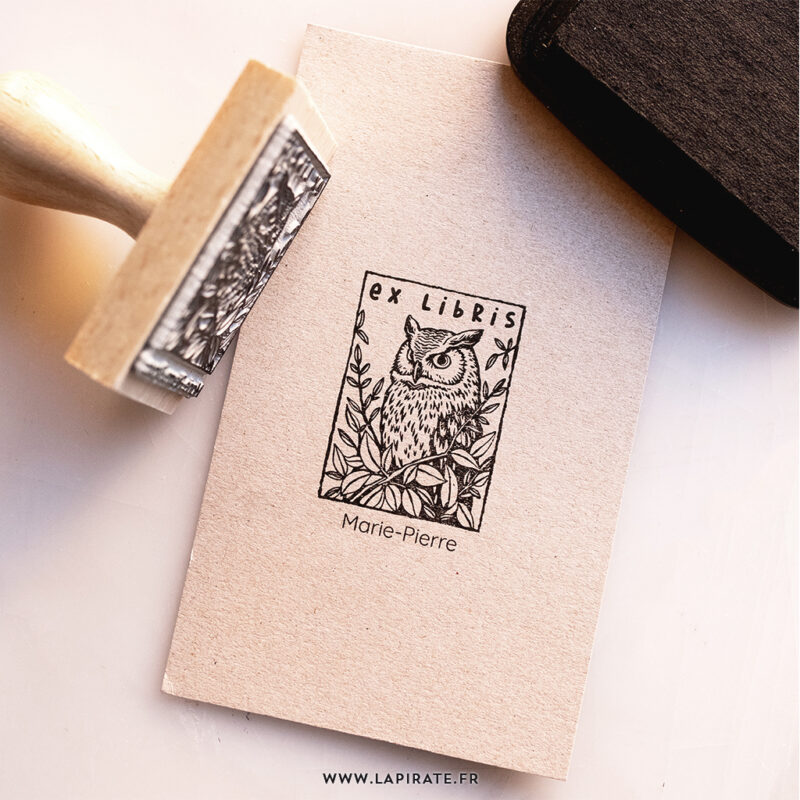Tampon ex libris Chouette personnalisé - tampon pour livres illustré d'une chouette au regard perçant entourée de feuillage luxuriant. Tampon à personnaliser de votre nom pour estampiller vos livres - Idée cadeau originale - La Pirate