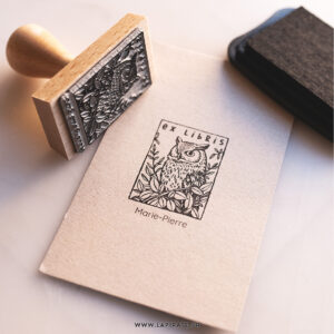 Tampon ex libris Chouette personnalisé - tampon pour livres illustré d'une chouette au regard perçant entourée de feuillage luxuriant. Tampon à personnaliser de votre nom pour estampiller vos livres - Idée cadeau originale - La Pirate